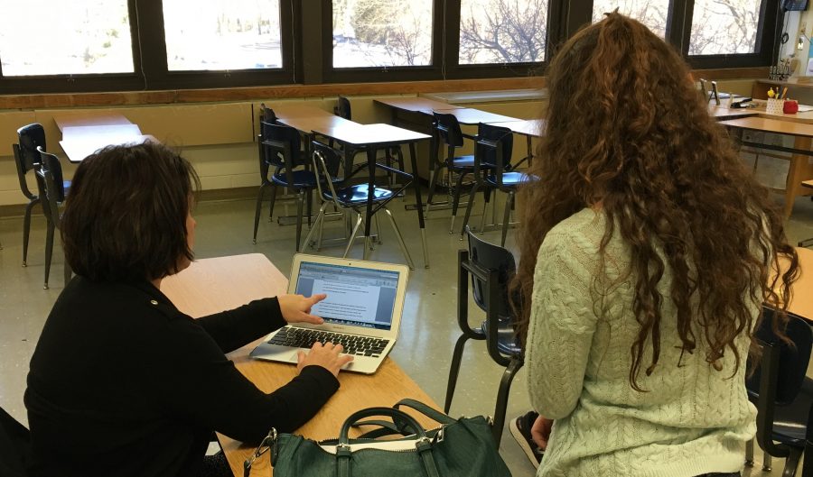 English teacher Jennifer Dee assists a student with her genius project, the research component of English II Honors