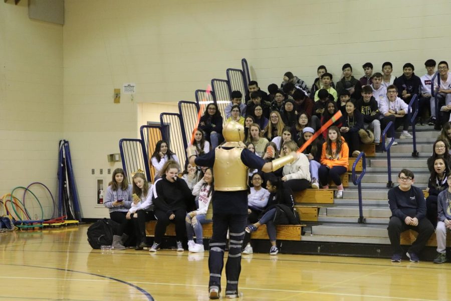 The mascot waving glow sticks in the South Gym.