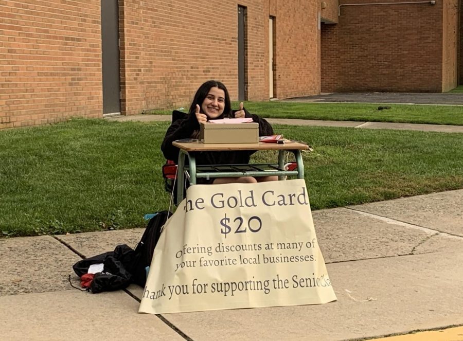 Ava Petrilli, senior class president, selling Gold Cards in front of the school.