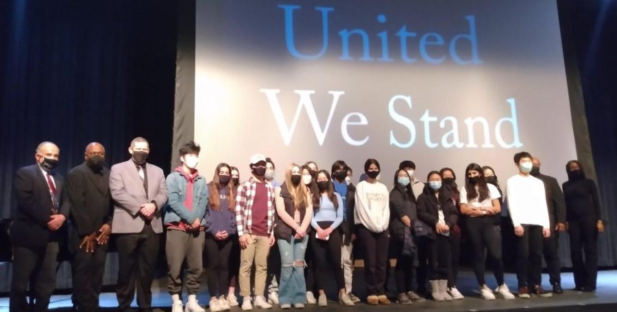 Students join the United We Stand performers on stage after the assembly.