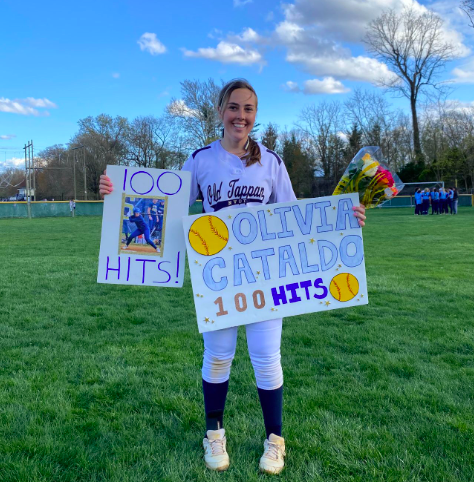 Cataldo poses with posters after earning her 100th hit.