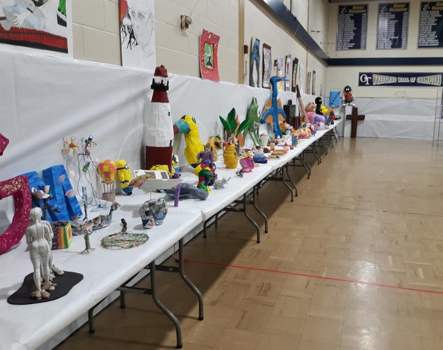 3-D pieces and sculptures span a wall at the art show.