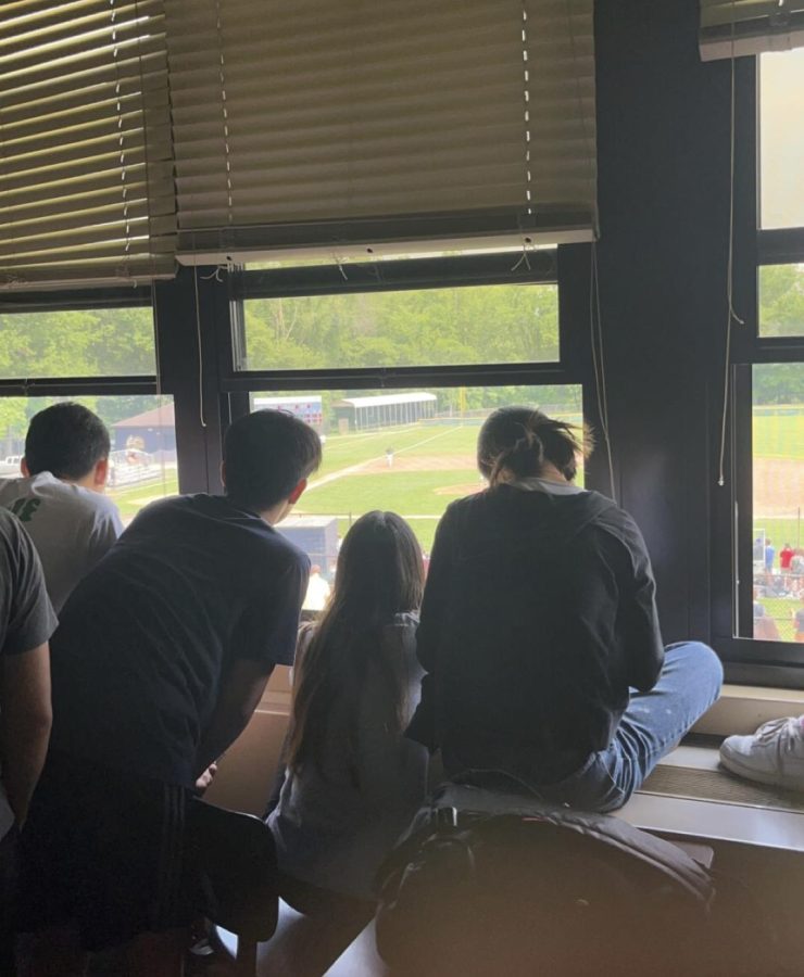 Students watch the baseball game from a classroom window.