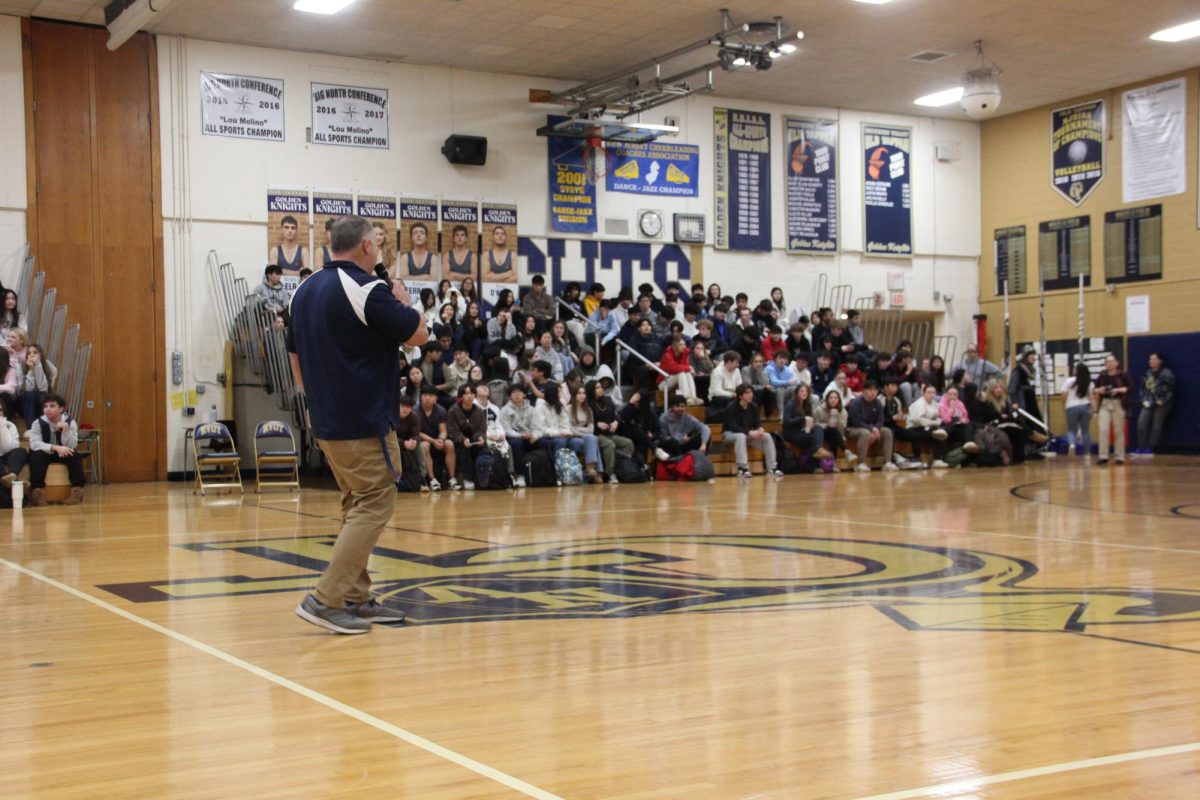 Athletic Director Lorenzo Baratta delivers the pep rally opening remarks
