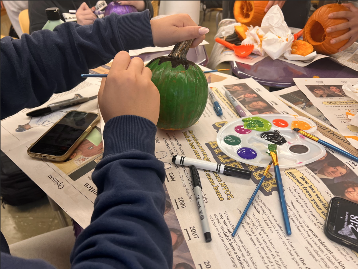 The Lance staff member painting one of the Frankenstein-inspired pumpkin.